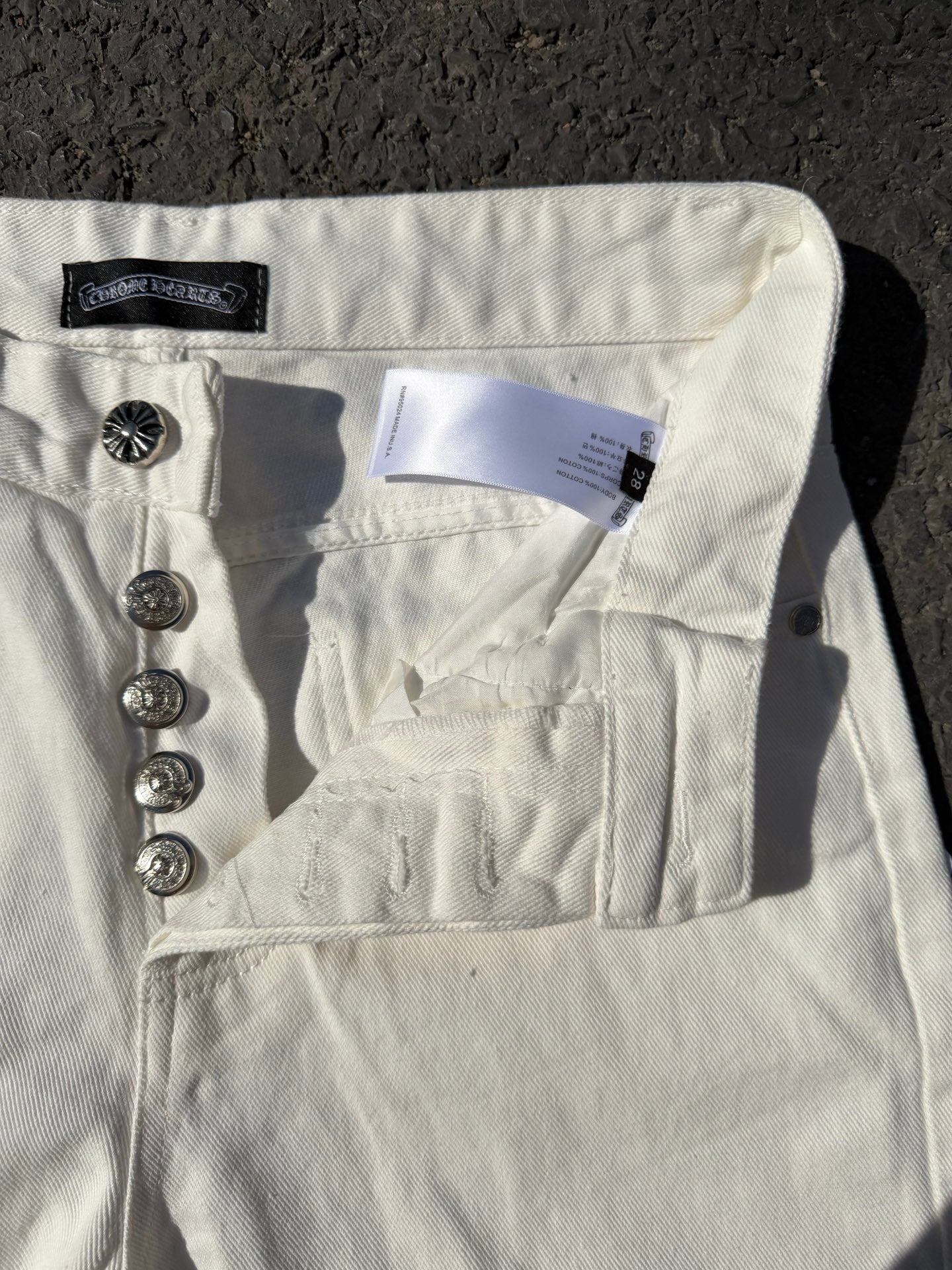 White denim pants with back yoke, patch pocket, and metal button hardware