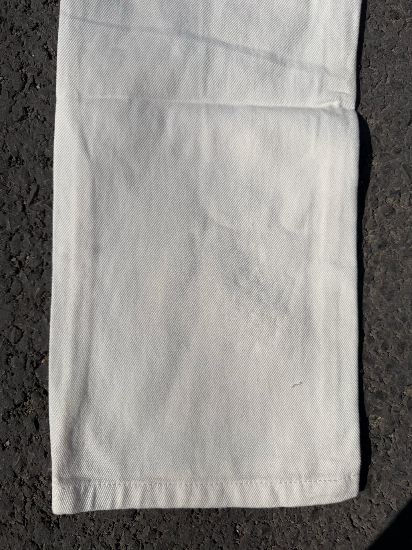 Light-colored pants with straight leg and stitched hems