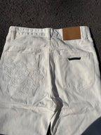 White denim pants with floral stitched panel on the back and front slant pocket