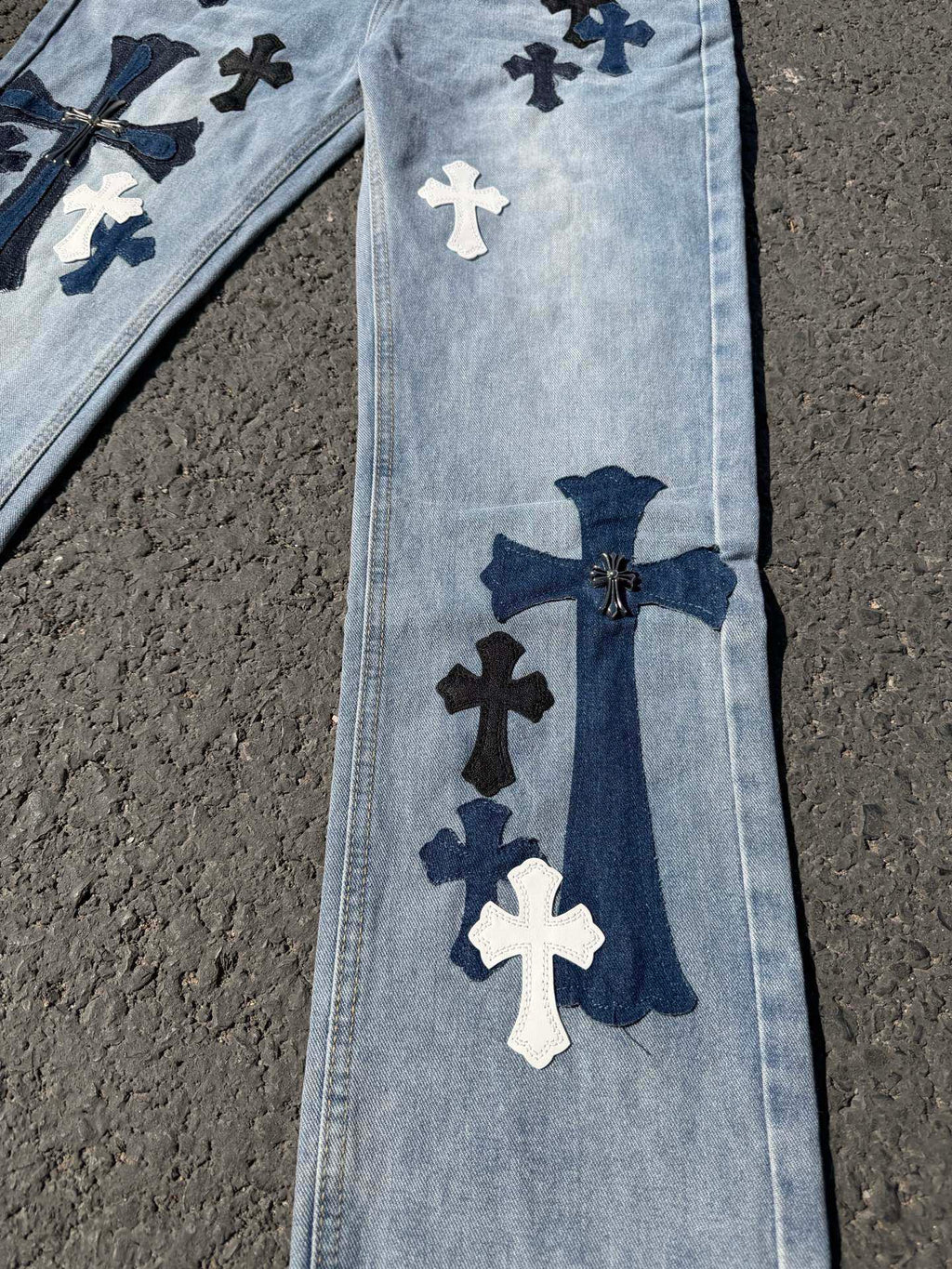 Light wash denim pants with vertical cross applique and navy bow detail