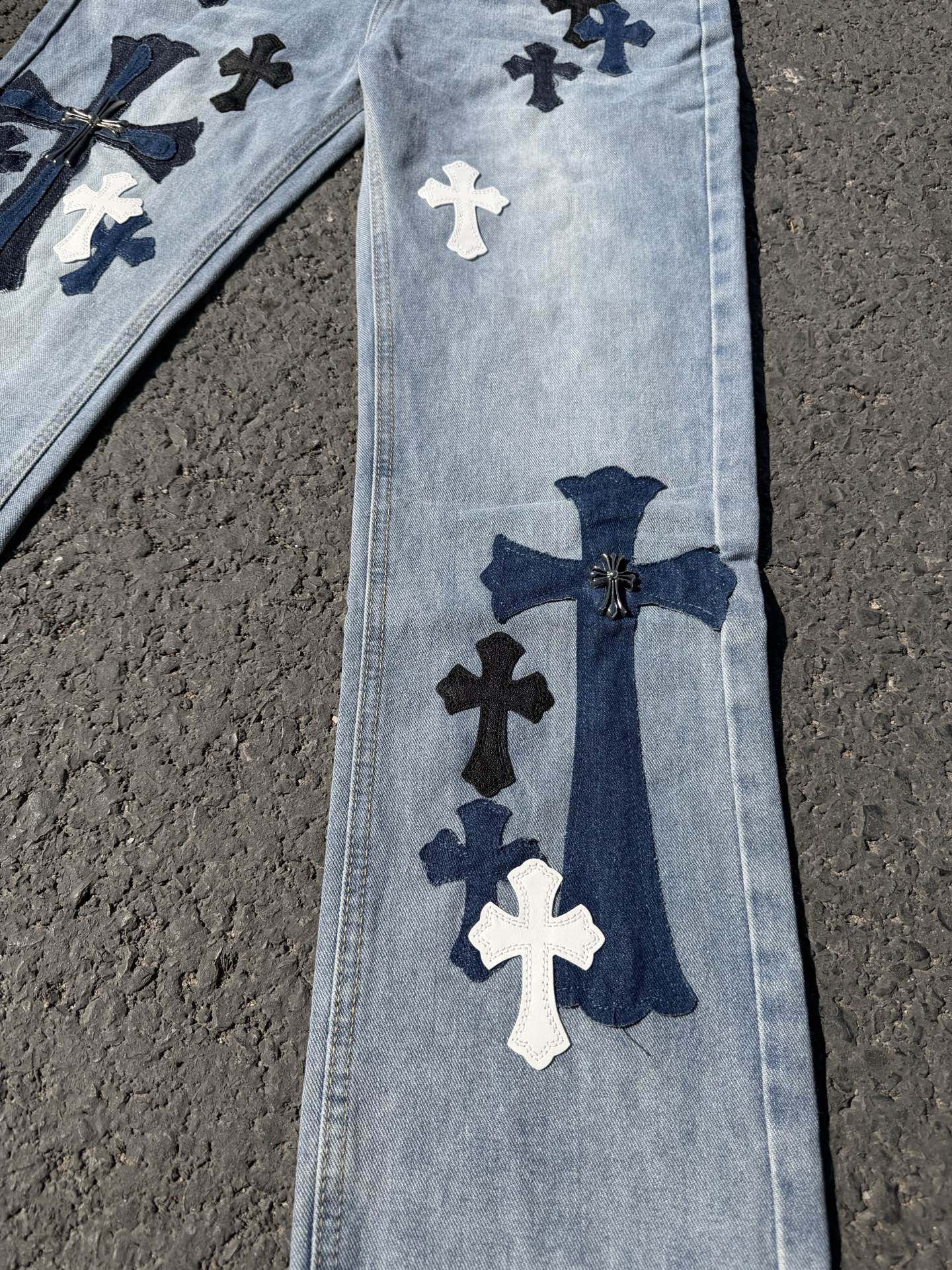 Light wash denim pants with vertical cross applique and navy bow detail