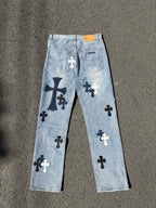 Light wash denim pants with scattered cross patches and back pockets