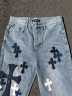 Light wash denim pants with front pockets and navy cross appliques