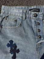 Light wash denim pants with front button placket and navy cross patch on pocket
