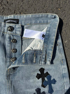 Light wash denim pants with snap waistband details and cross patch on back