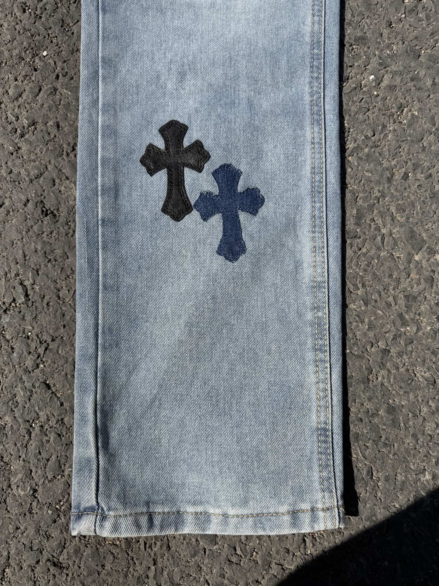 Light blue denim pants side panel with dark cross applique and white cross