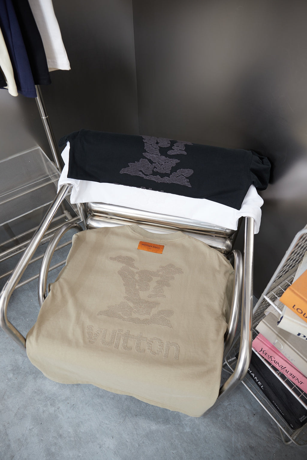 Stack of beige and black Louis Vuitton T-shirts with monogram-style prints