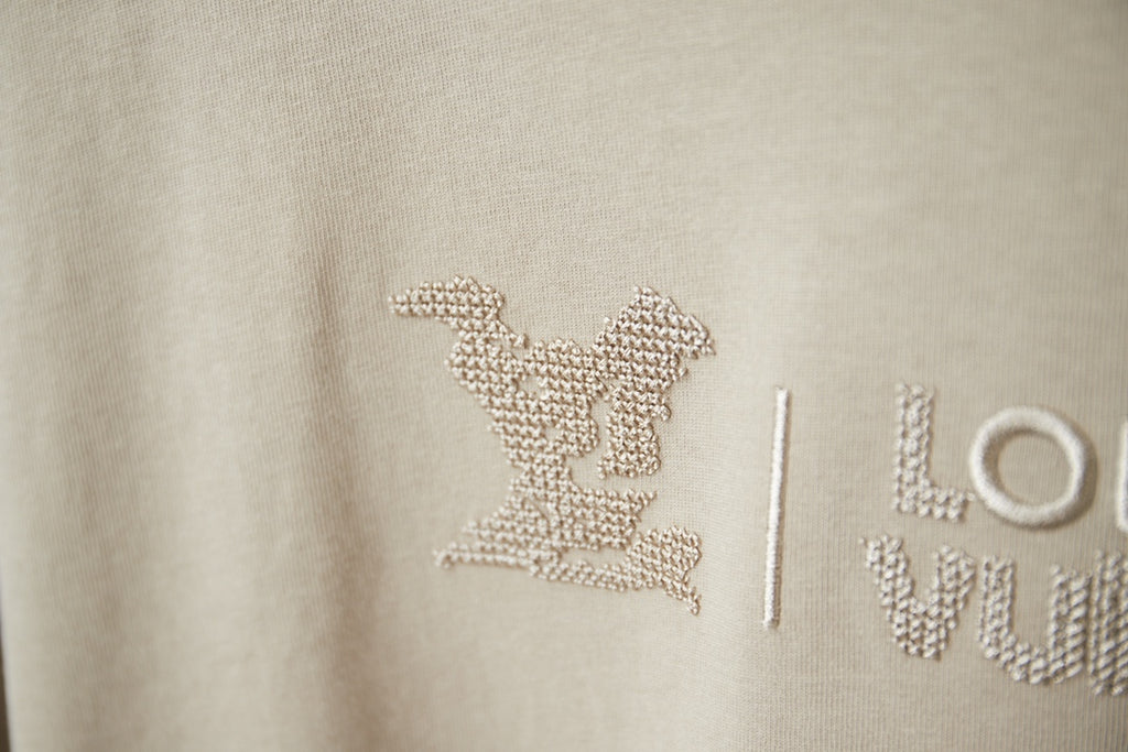 Beige Louis Vuitton T-shirt logo with rhinestone-style emblem and letters