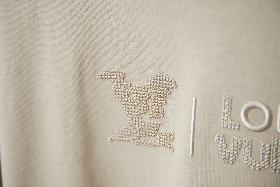 Beige Louis Vuitton T-shirt logo with rhinestone-style emblem and letters