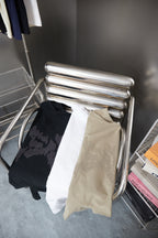Stack of black and beige Louis Vuitton T-shirts on metal display rack