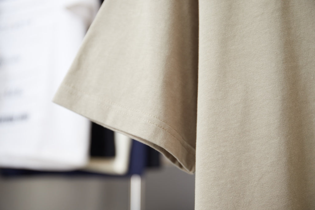 Beige Louis Vuitton T-shirt side view showing short sleeves and curved hem