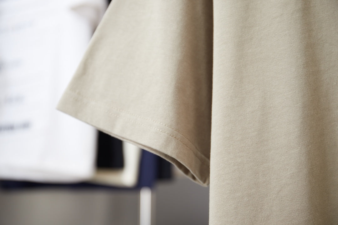 Beige Louis Vuitton T-shirt side view showing short sleeves and curved hem