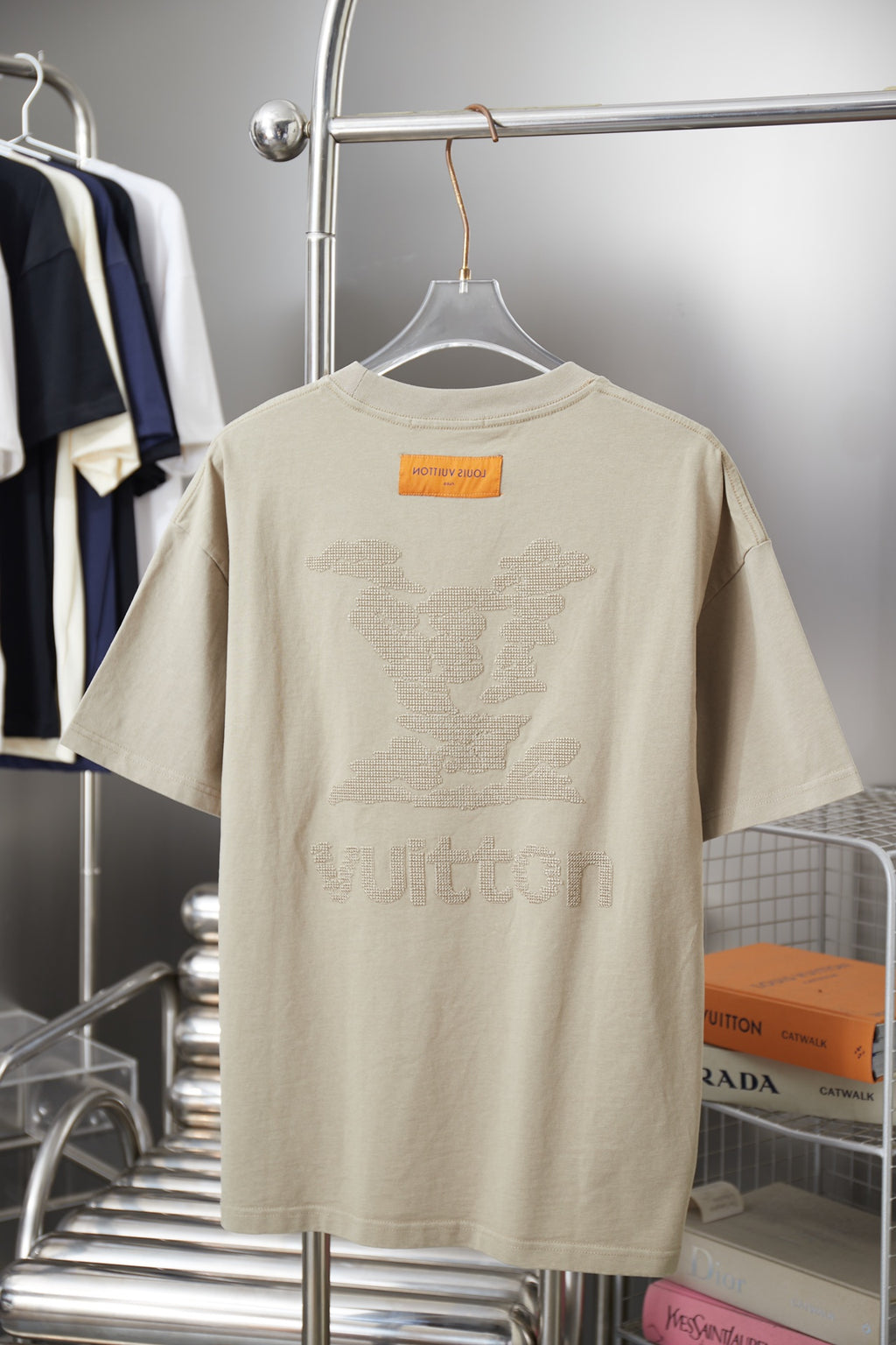 Beige Louis Vuitton T-shirt on hanger with rhinestone-style back graphic