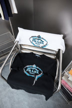 Folded white and black Prada T-shirts with embroidered PRADA Milano logos