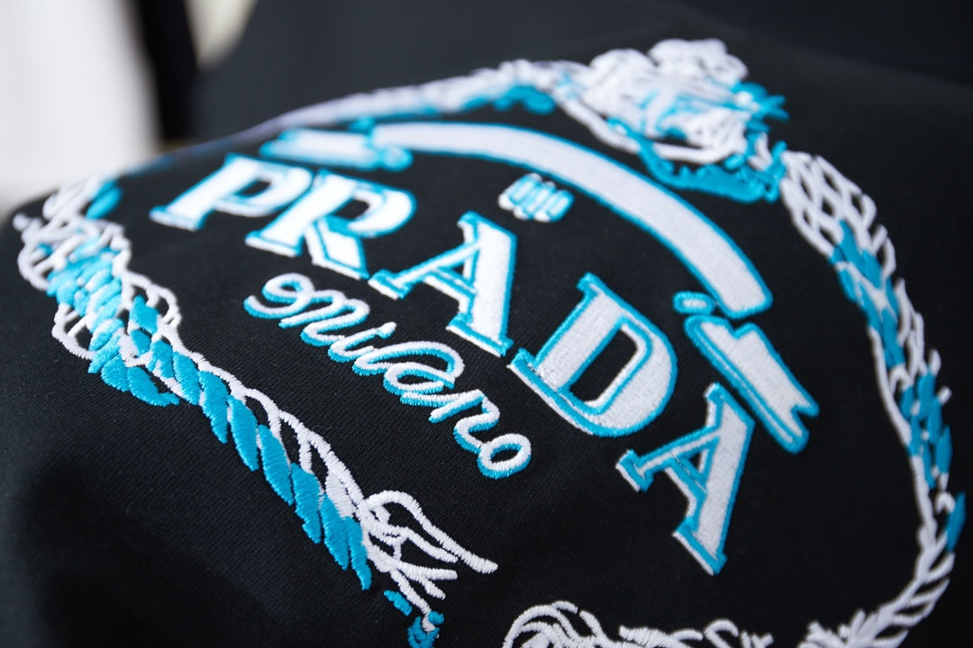 Black embroidered Prada Milano graphic with blue and white thread detail