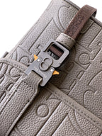 Dior taupe bag close-up with flap buckle hardware and embossed monogram texture