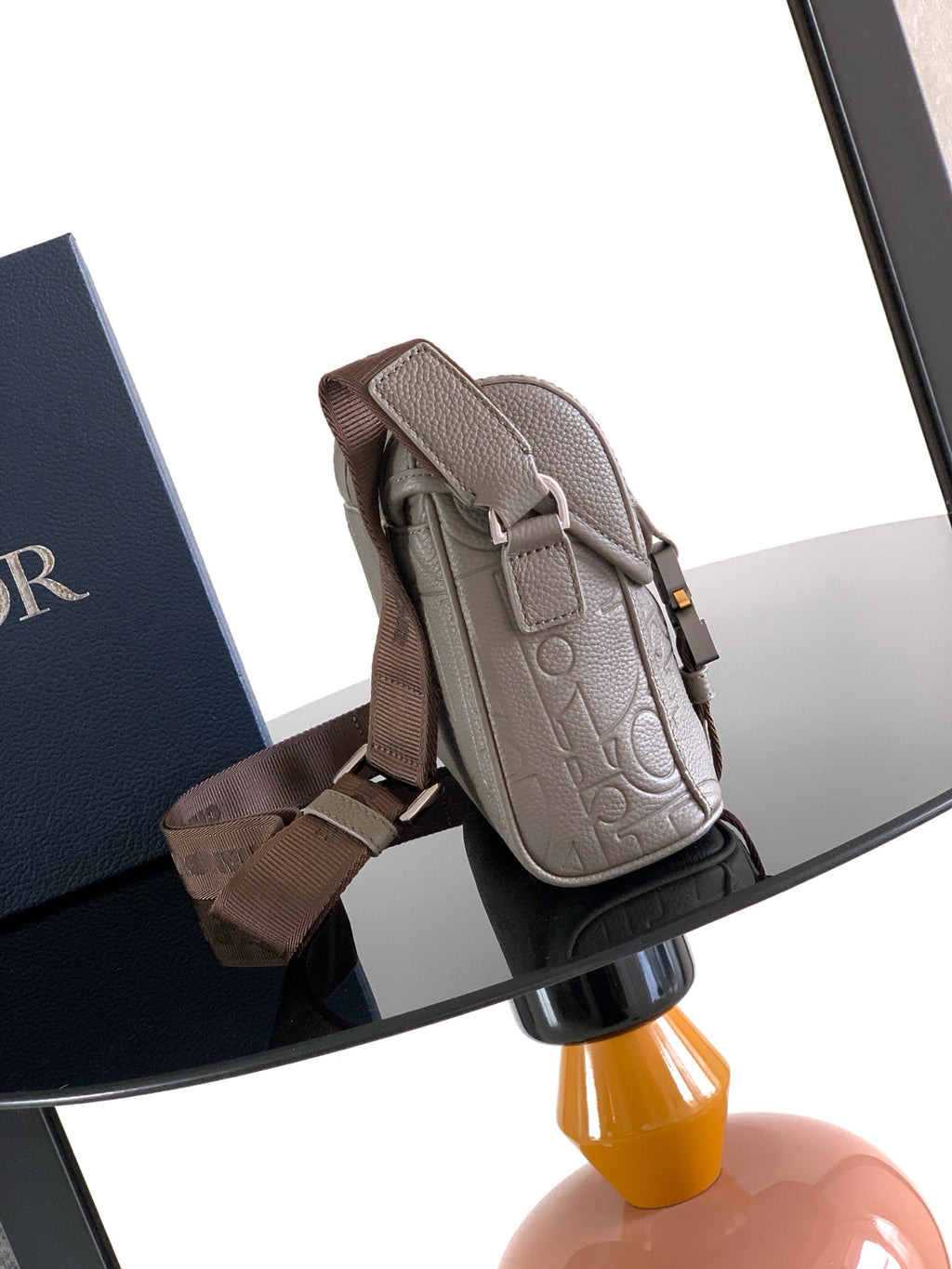 Dior embossed taupe crossbody bag with side buckle strap and top carry handle