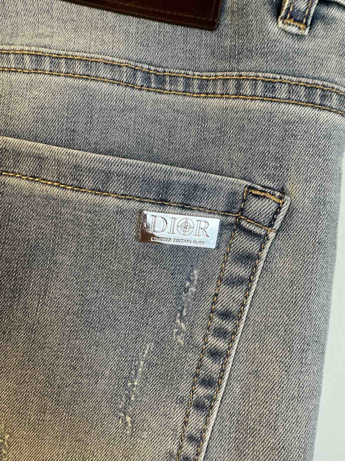 Light blue denim jeans pocket with embroidered DIOR label on stitched seam.
