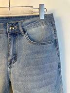 Light blue denim jeans with coin pocket and belt loops, hanging tag partially visible.