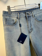 Light blue denim pants front, showing coin pocket, belt loops, and hanging tag