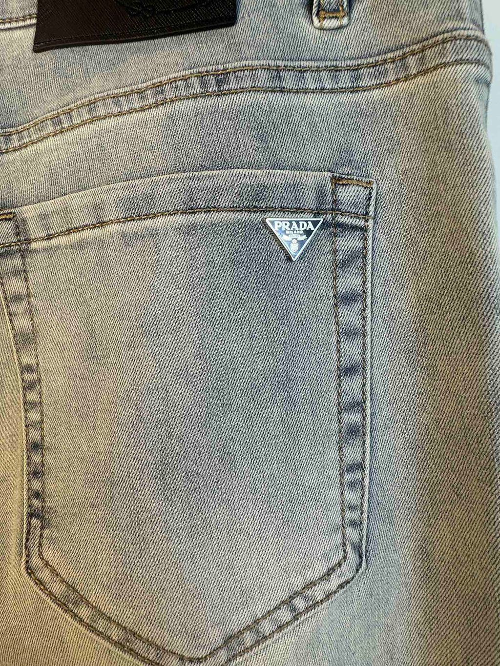 Light blue denim pocket with triangular Prada logo patch
