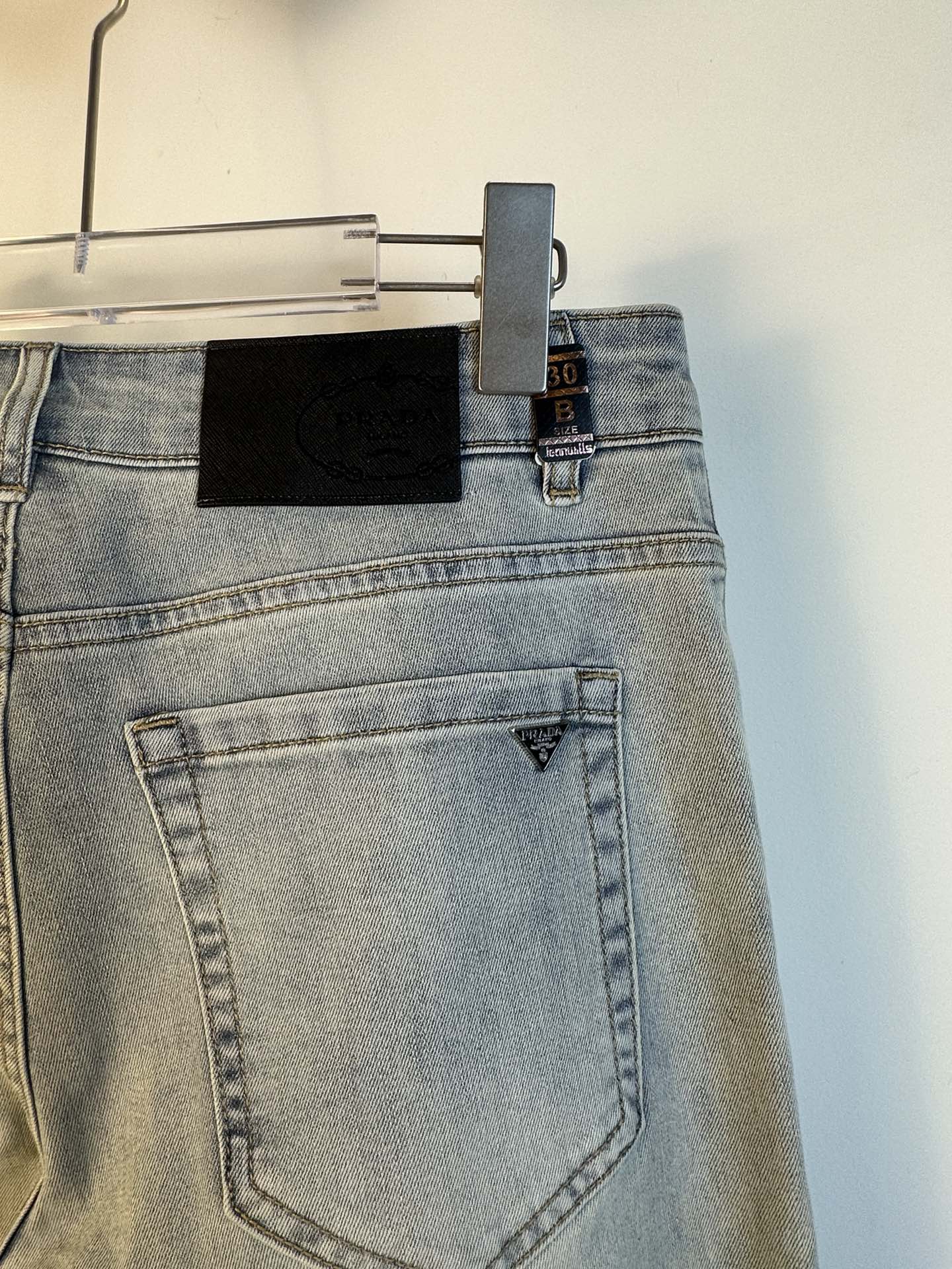 Light blue denim back pocket with triangular Prada logo patch