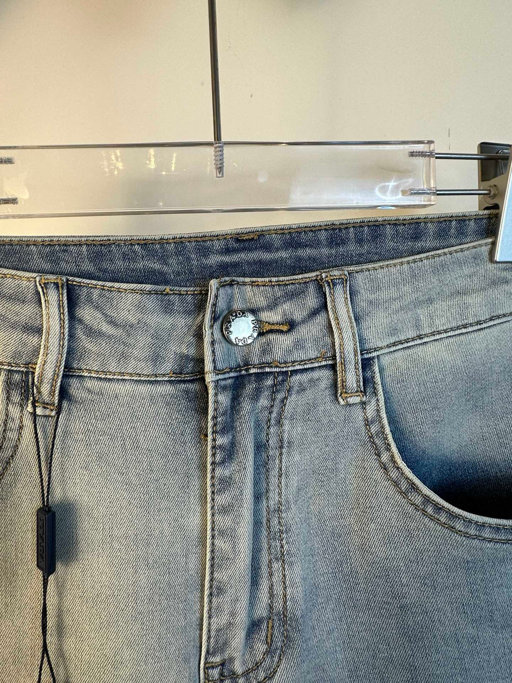 Light blue denim waistband with decorative ring detail and belt loops