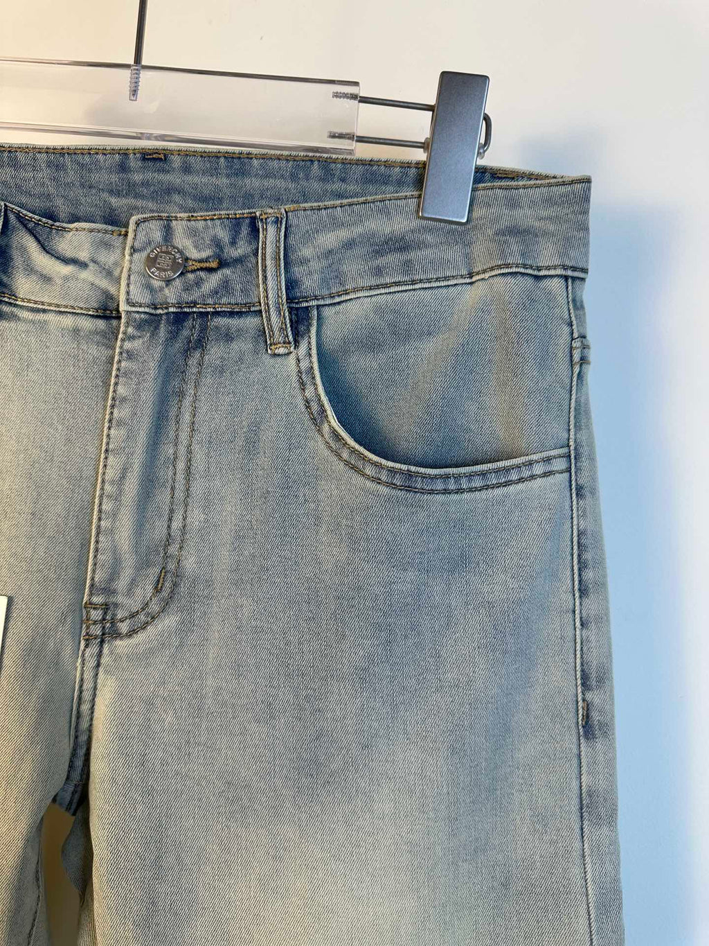 Light-wash denim jeans close-up at waistband with belt loop and large front pocket