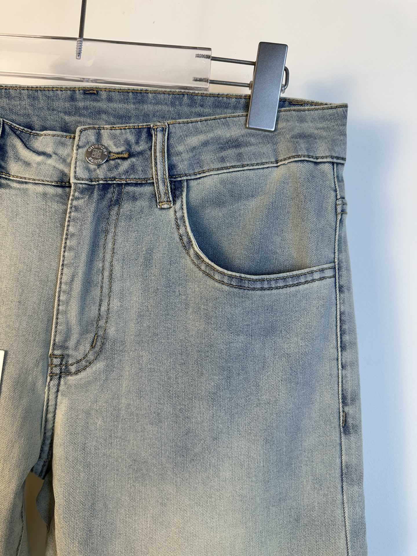 Light-wash denim jeans close-up at waistband with belt loop and large front pocket