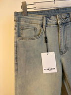 Givenchy light-wash denim jeans close-up at waist with front pockets and hanging tag