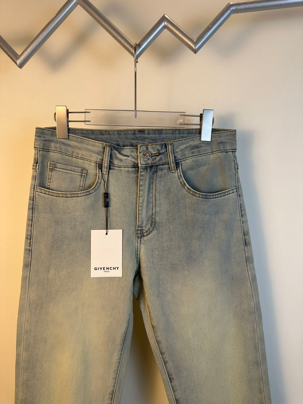 Givenchy light-wash denim jeans with five-pocket styling, belt loops, and hanging tag