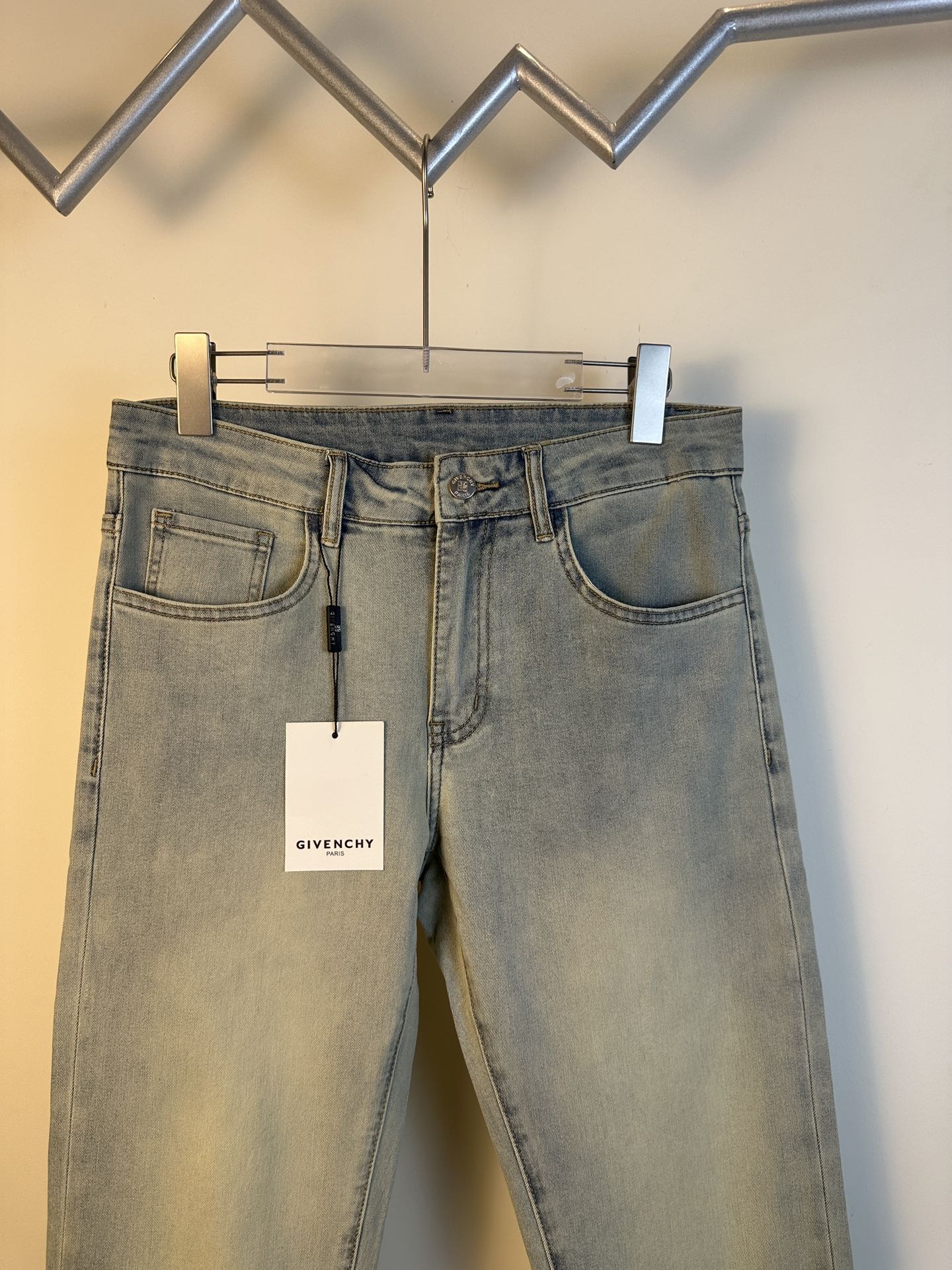 Givenchy light-wash denim jeans with five-pocket styling, belt loops, and hanging tag