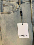 Light-wash denim jeans close-up of front pocket with hanging Givenchy tag