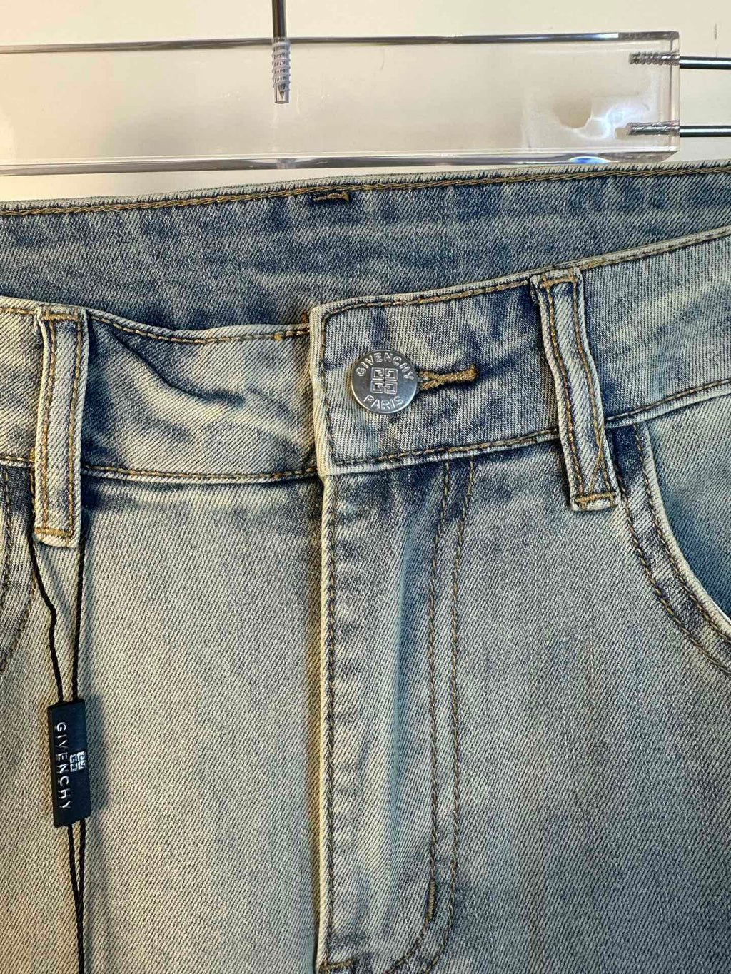 Light-wash denim jeans waistband and back yoke with two back pockets and hanging tag
