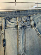 Light-wash denim jeans waistband and back yoke with two back pockets and hanging tag