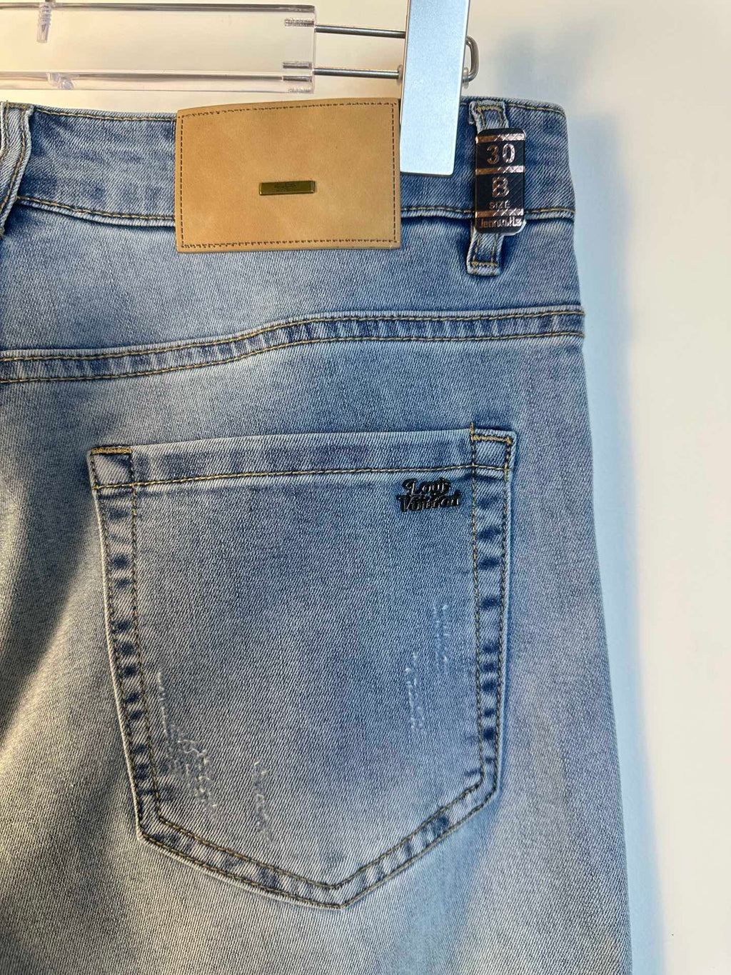 Louis Vuitton denim pants back pocket close-up with stitched edge and logo print