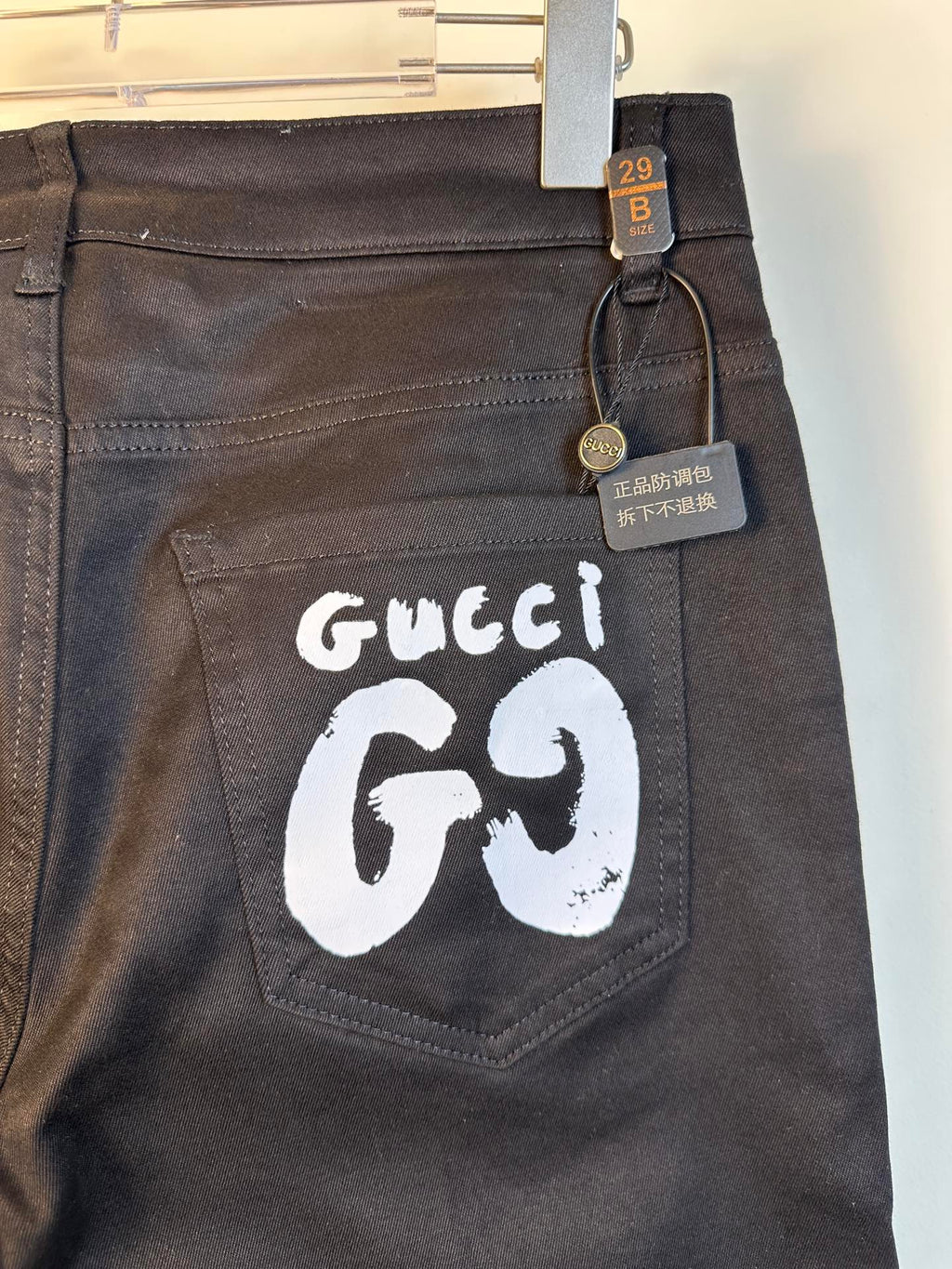 Black pants with large white GG69 logo patch on back pocket area