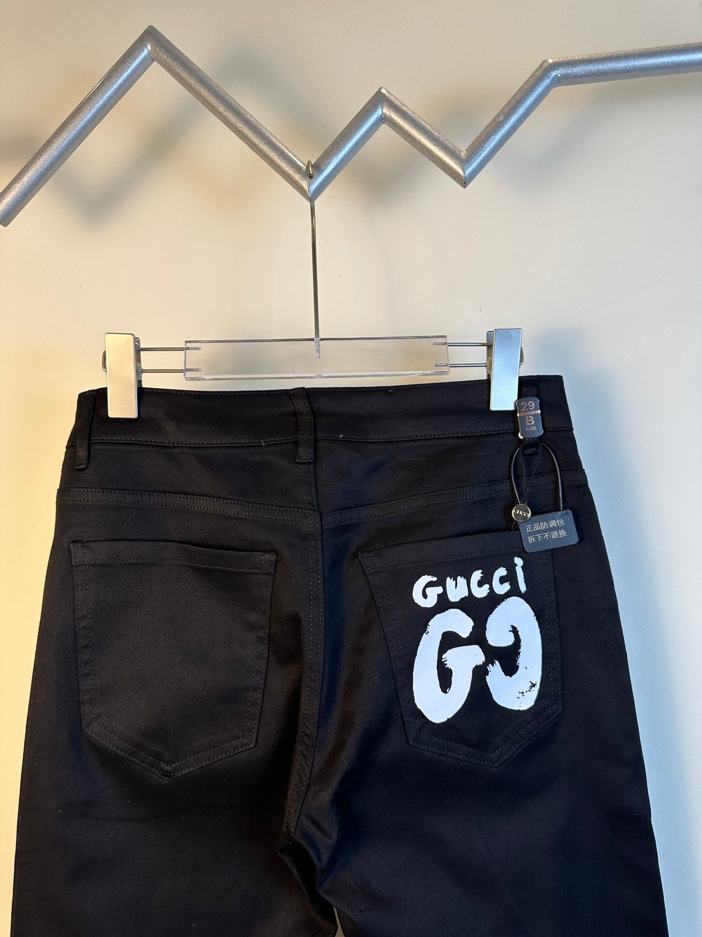 Black pants on hanger, front pockets, with white GG69 logo patch
