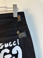 Black pants close-up of white GG69 logo patch and hanging size label