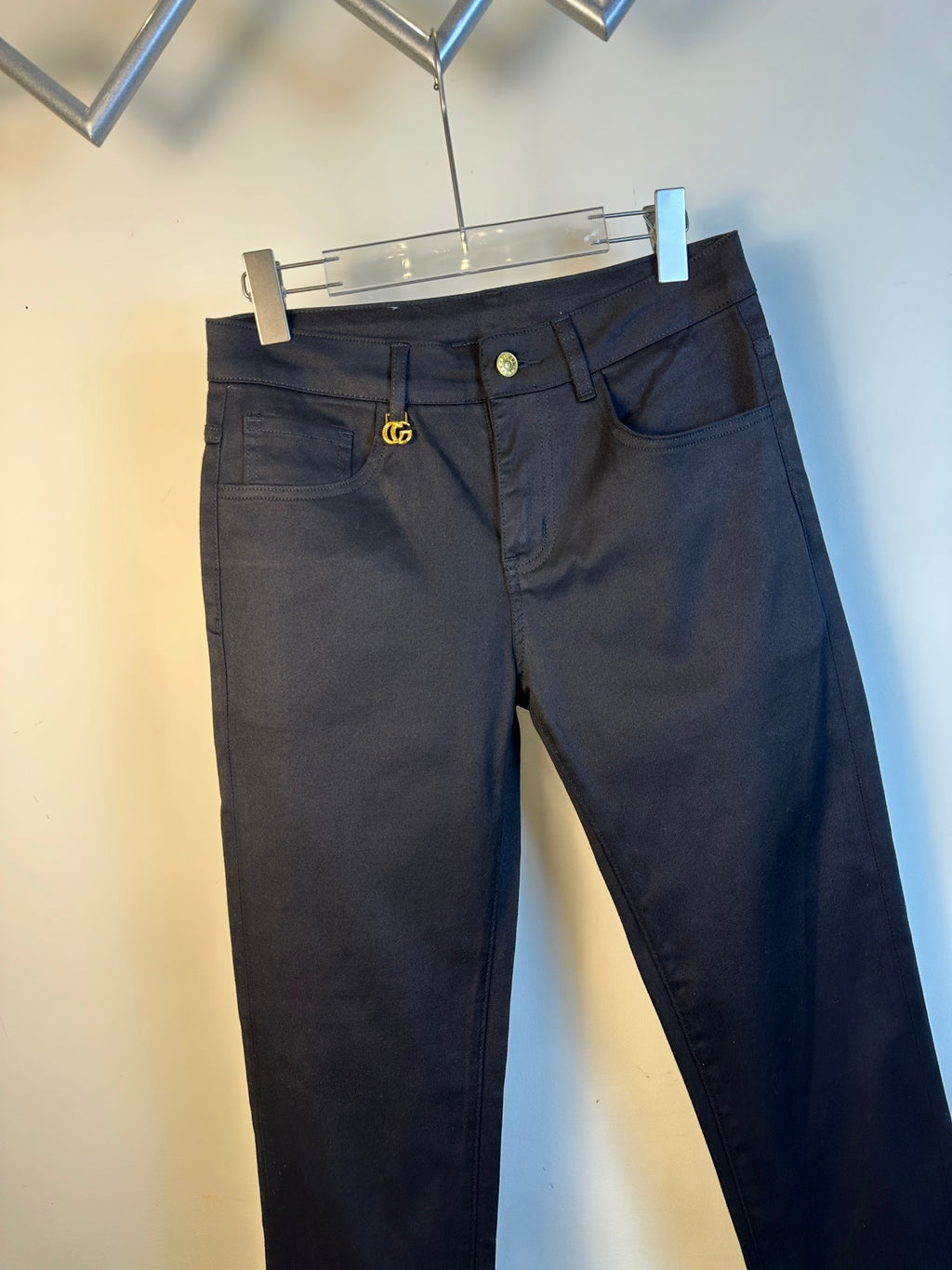 Black pants with front button, belt loops, and small gold GG emblem