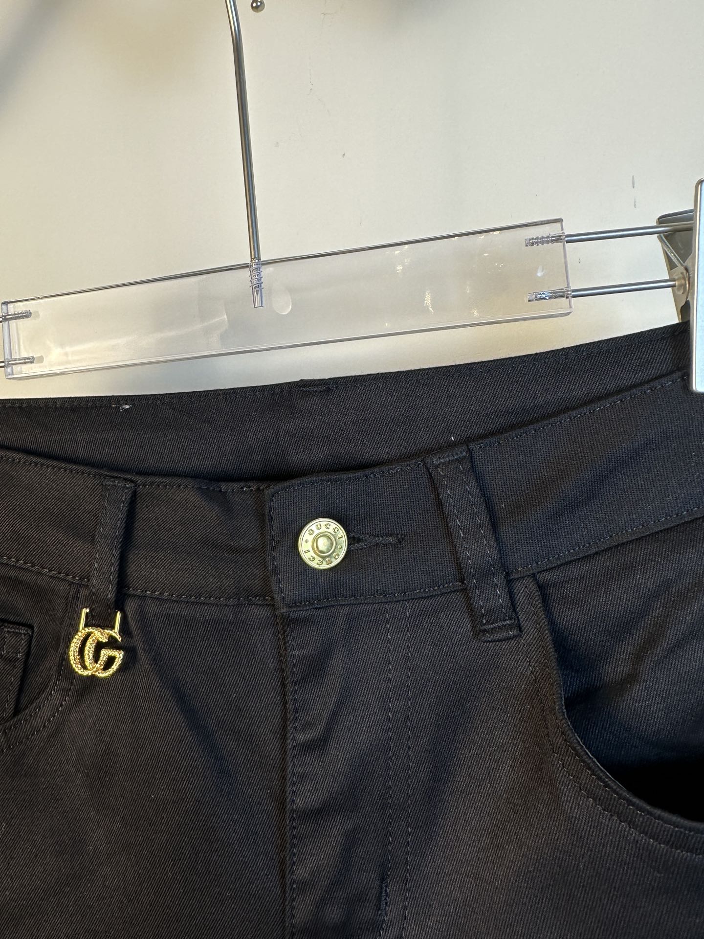 Black pants close-up of waistband and button with gold GG emblem