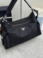 Prada bag in dark nylon with adjustable strap, silver zipper, and logo plaque