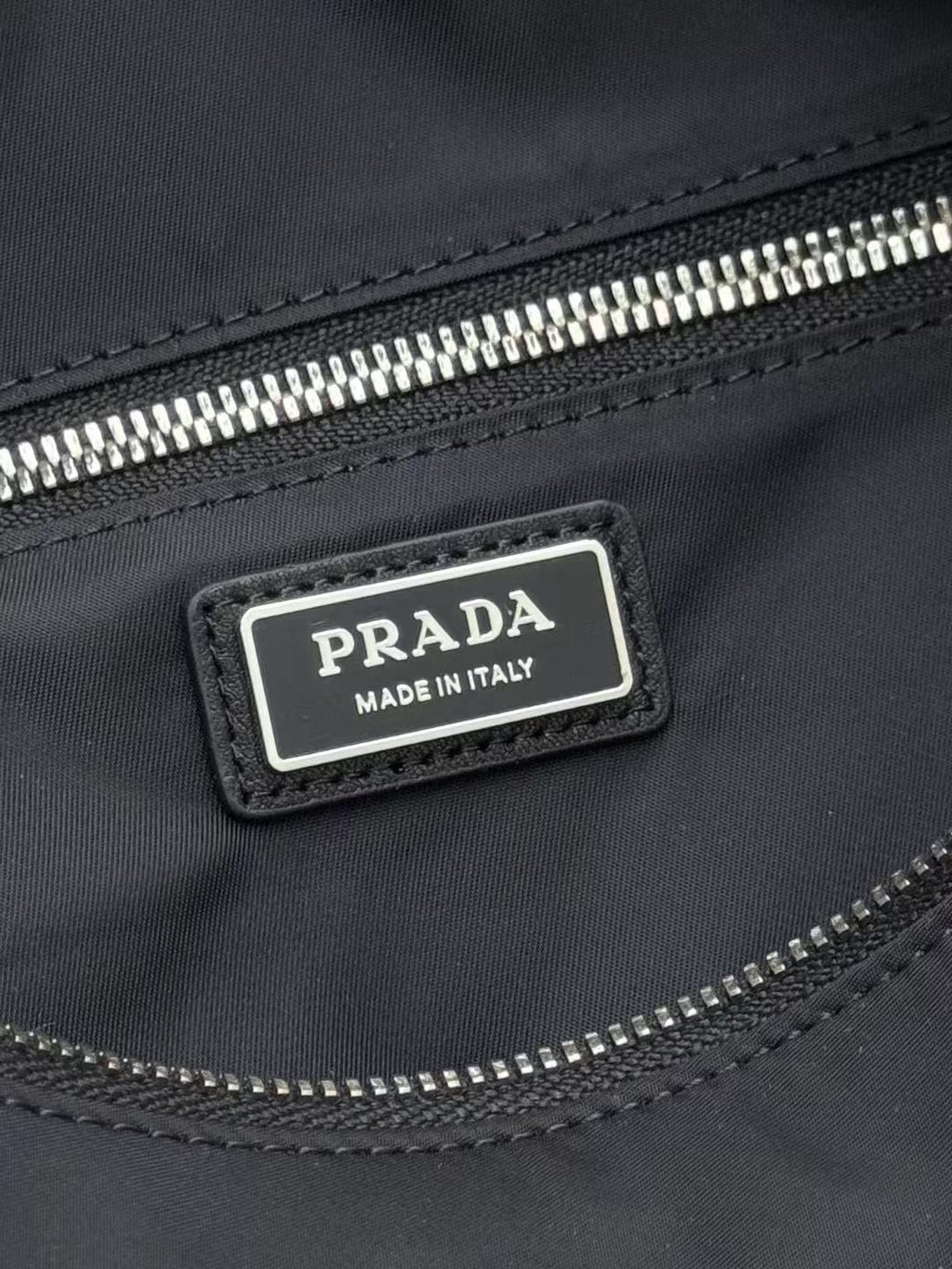 Prada "Made in Italy" label on dark nylon zip pocket