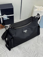 Prada bag in dark nylon with shoulder strap, front flap detail, and logo plaque