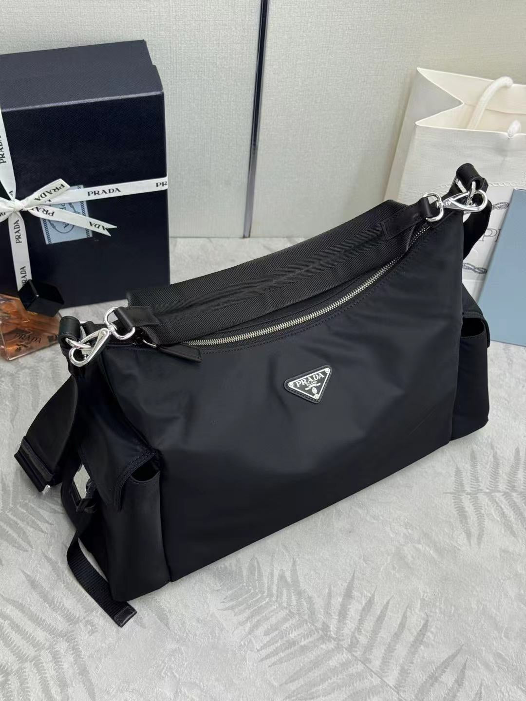 Prada bag in dark nylon with shoulder strap, front flap detail, and logo plaque