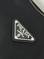 Prada logo patch on dark nylon with stitched border and triangular design