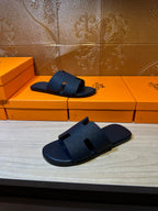 Blue slide sandals pair with wide cross straps, angled views