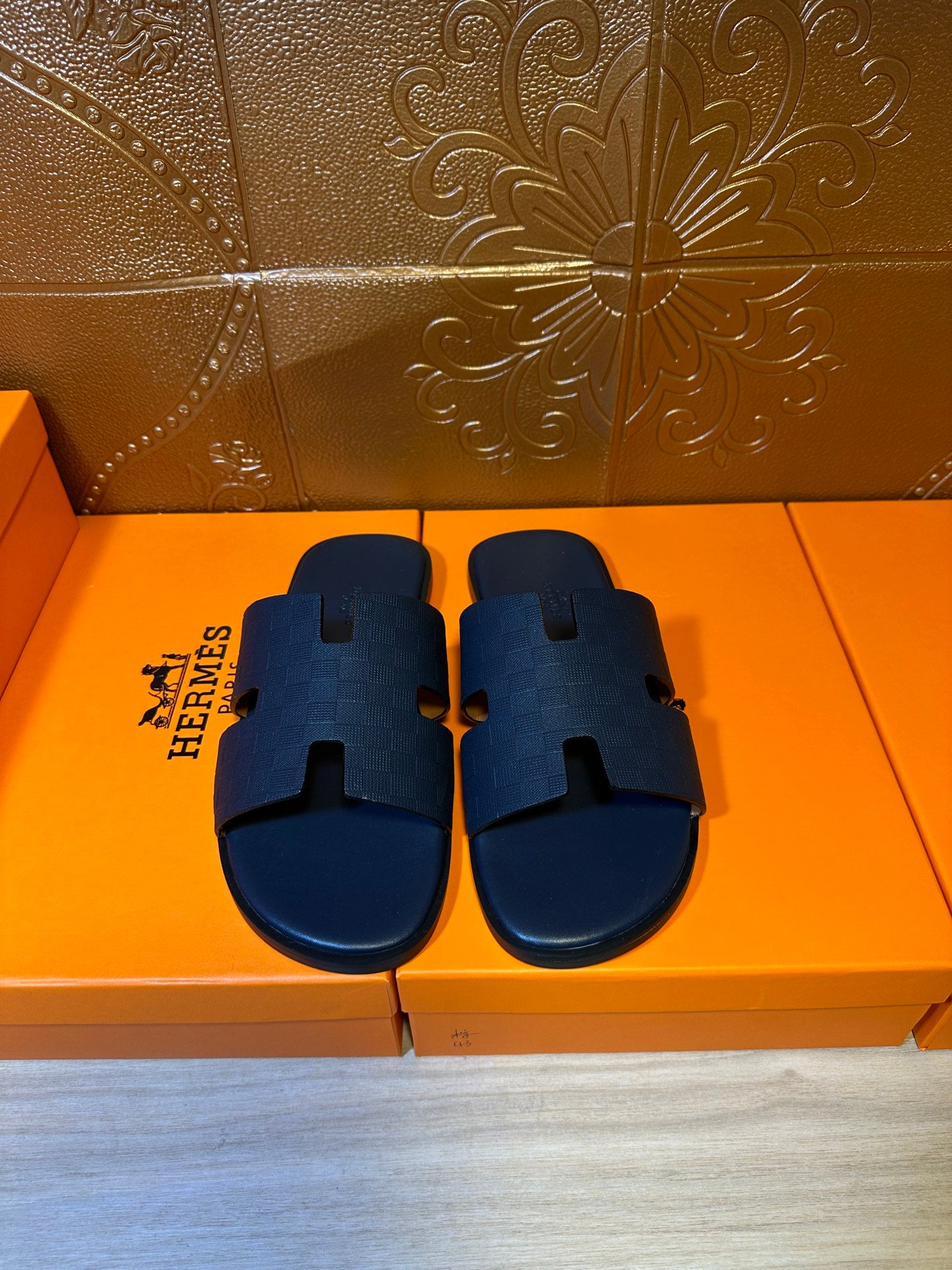 Blue slide sandals with wide cross straps and embossed pattern