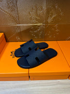 Blue slide sandals with wide cross straps, side profile