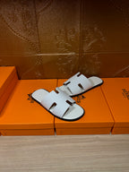 Hermes white slide sandals with wide molded strap and open toe cutouts